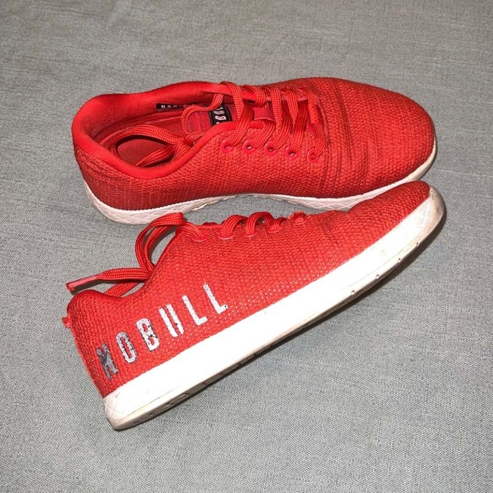 Red trainers. Well loved. The letters are not coming off that is the lighting.